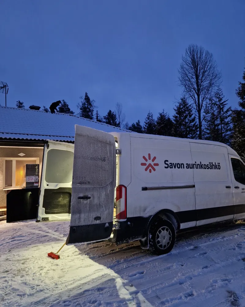 Savon Aurinkosähkön asennusauto omakotitalon pihalla talvi-iltana asennuksen aikana